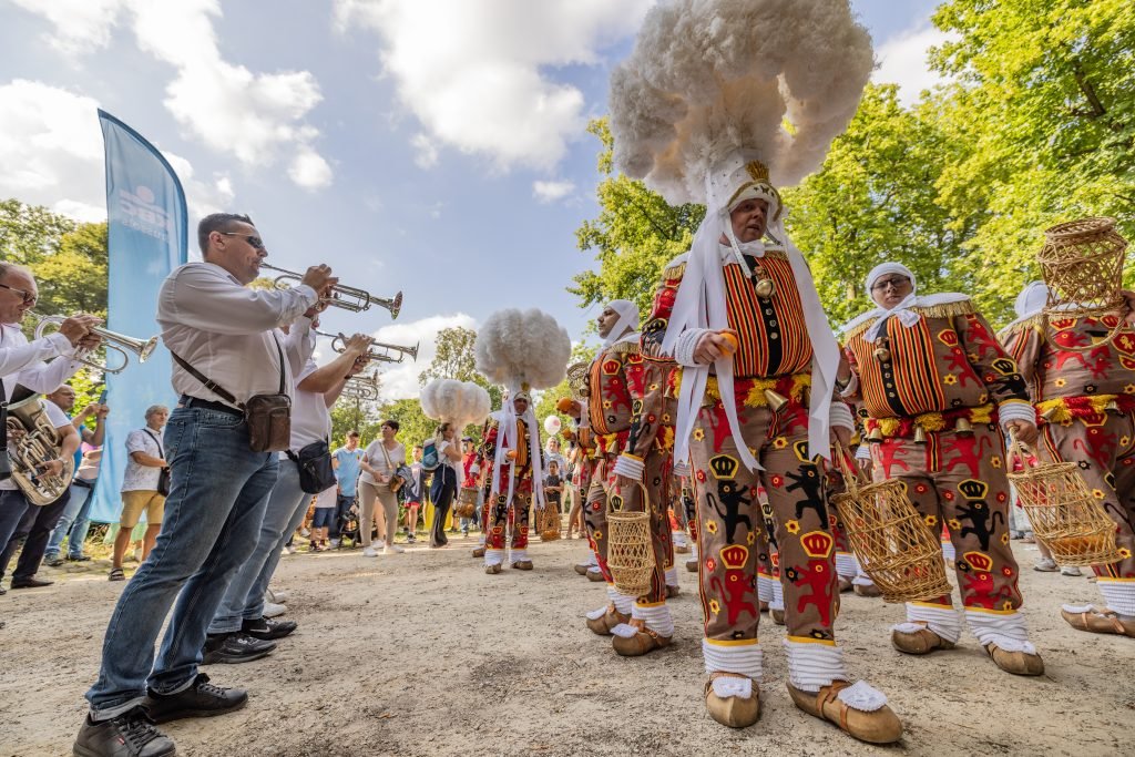 Gilles et musiciens folkloriques lors du cortège dans la rue