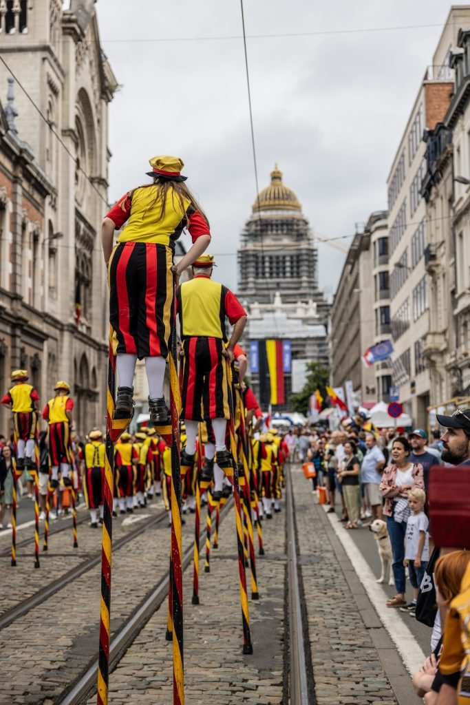 Échassiers et géants folkloriques défilant devant le Palais de Justice