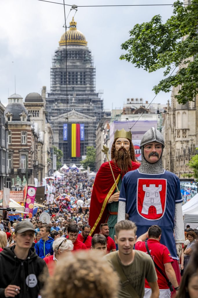 Géant folklorique dans la foule sur une avenue menant au Palais de Justice