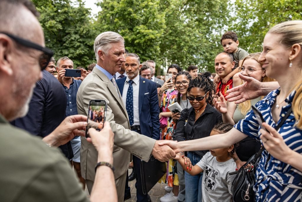 Le Roi serre des mains dans la foule lors de la fête au parc